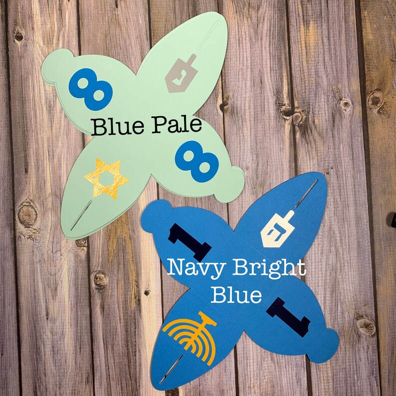 May include: Two butterfly-shaped favor boxes, one in pale blue with gold accents and the text "Blue Pale", and the other in navy blue with the text "Navy Bright Blue".