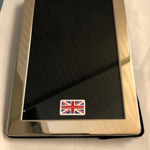 以下が含まれることがあります： 黒いマットと「100％イギリス製手作り」とユニオンジャックの旗が書かれた小さなステッカーが付いた銀色の写真フレーム