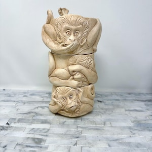May include: A ceramic sculpture of three monkeys stacked on top of each other. The monkeys are all in different poses, and their faces are visible. The sculpture is painted in a light brown color.
