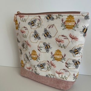 Small lined (and interlined with batting) zippered bag made in adorable bee and beehive fabric with  a fun coordinating lining