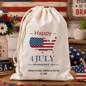 Può includere: Una borsa con coulisse color crema con un design patriottico per il 4 luglio. La borsa presenta una mappa degli Stati Uniti con un design a bandiera, le parole "Happy 4 July Independence Day" e testo personalizzato. Decorazioni patriottiche.