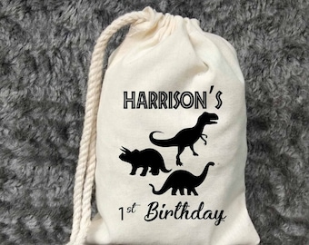 May include: A white cotton drawstring bag with black dinosaur silhouettes and the text "HARRISON'S 1st Birthday".