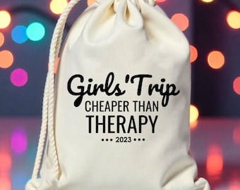Może przedstawiać: Biała torba sznurkowa z nadrukiem "Girls' Trip Cheaper Than Therapy... 2023..." w kolorze czarnym.