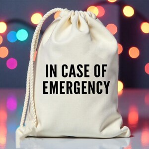 May include: A white drawstring bag with the text "IN CASE OF EMERGENCY" printed in black.
