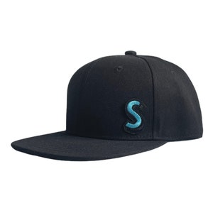 Op de afbeelding: Een zwarte baseballpet met een blauwe geborduurde letter 'S' op de voorkant.