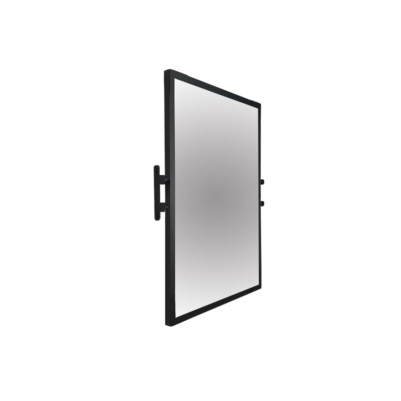 May include: A black framed rectangular mirror with a simple design. The mirror is mounted to a wall with two black metal brackets.
