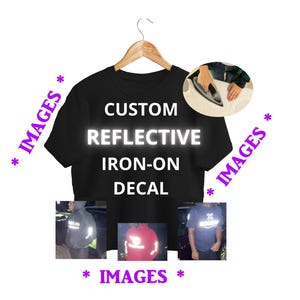 Può includere: Una t-shirt nera su una gruccia di legno con il testo bianco CUSTOM REFLECTIVE IRON-ON DECAL. L'immagine include un inserto circolare che mostra un ferro da stiro su tessuto e tre piccole foto che mostrano la decalcomania riflettente sui vestiti.