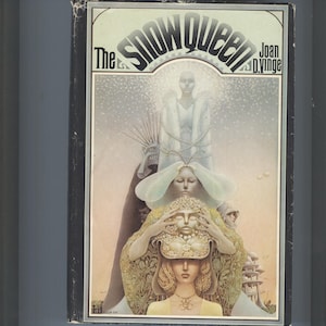 May include: The Snow Queen book cover features a colorful illustration of three women with a snowy background. The title "The Snow Queen" is in large, bold letters at the top of the cover. The author's name, "Joan D. Vinge", is in smaller letters below the title.