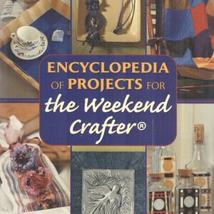Könnte beinhalten: Das Cover von "Enzyklopädie der Projekte für den Wochenend-Bastler" zeigt eine Collage von Bastelprojekten. Der Titel des Buches steht in großen weißen Buchstaben auf blauem Hintergrund. Das Bild enthält Beispiele für Papierbasteln, Trockenblumenbasteln und Metallprägen.