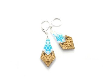 May include: A pair of geometric earrings with a blue and white pattern on the top half and a wood grain pattern on the bottom half.