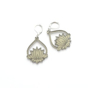 May include: A pair of silver earrings with a detailed lotus flower design. The earrings are teardrop shaped and have a silver hook closure.