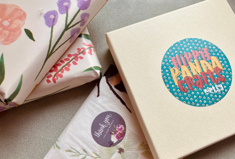 Pode incluir: Tr&ecirc;s presentes embrulhados com papel estampado floral. Uma caixa de presente tem um adesivo que diz "Obrigado pelo seu neg&oacute;cio!" Outra caixa de presente tem um adesivo que diz "Hippie Panda Crafts Etsy".