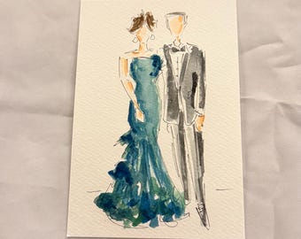 May include: Watercolor illustration of a couple in formal attire. The woman wears a teal off-the-shoulder gown with ruffled accents. The man is in a black tuxedo with a bow tie. The artwork is on a rectangular piece of paper.