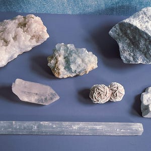 May include: Assortment of various crystals and minerals, including quartz, selenite, and desert roses. The collection features a range of colors from clear to white and light blue, with varying textures and shapes. Ideal for collectors or those interested in geology.