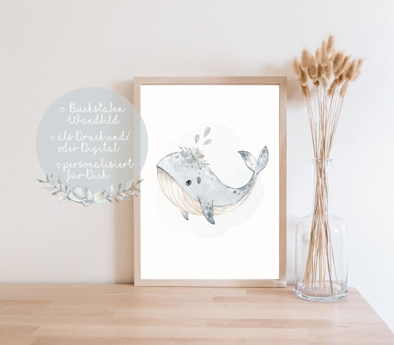 Puede incluir: Una ilustraci&oacute;n acuarela enmarcada de una ballena azul claro con una corona floral, sobre un fondo blanco. La ballena est&aacute; nadando con la boca abierta y tiene una barriga azul claro. El marco es de madera y tiene un acabado marr&oacute;n claro.