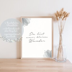Puede incluir: Una impresi&oacute;n enmarcada con fondo blanco y dise&ntilde;os grises que parecen acuarela. El texto "Du bist unser kleines Wunder" est&aacute; escrito en letra cursiva negra.