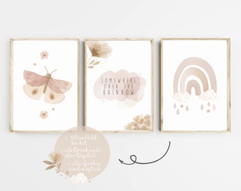 May include: Three watercolor prints in brown frames. The first print features a pink butterfly with flowers. The second print features a watercolor cloud with the text "Somewhere over the rainbow". The third print features a watercolor rainbow with clouds and raindrops.