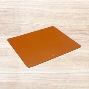 May include: A brown leather desk mat with the name "BEN" embossed in gold lettering.