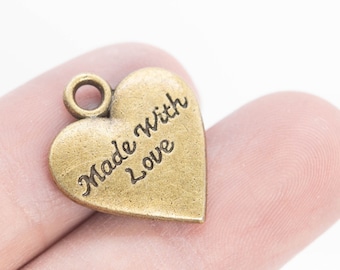 May include: A gold heart-shaped charm with the words "Made With Love" engraved on it.