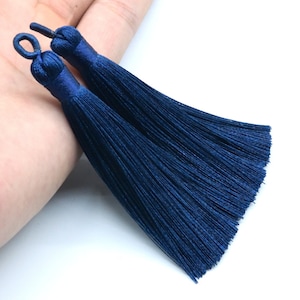 May include: Two dark blue silk tassels with a loop at the top.