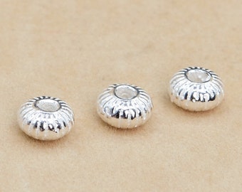 Può includere: Tre perline in metallo color argento con un design testurizzato e rigato. Le perline hanno un foro al centro per l'infilaggio.