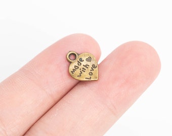 May include: A gold-coloured heart-shaped charm with the words "made with love" inscribed on it.