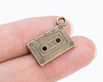 20 Charms de cinta magnética en tono bronce antiguo (66066-150)