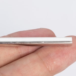May include: A silver metal tube with a smooth, polished finish.