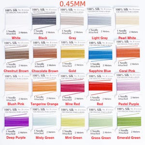 May include: A selection of silk thread spools in various colors, including white, black, gray, and red. Each spool is labeled with the thread color and specifications, such as 0.45mm thickness and 2 meters of thread.
