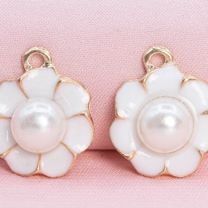 Dije de 12 flores esmaltadas en tono dorado con esmalte blanco (65598-3295)