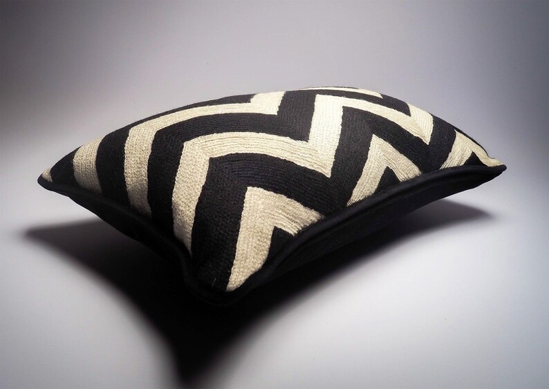May include: Black and white chevron patterned throw pillow with a black border.