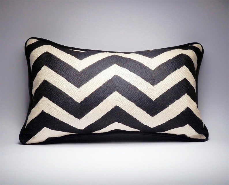 May include: Black and white chevron patterned throw pillow with a black border.