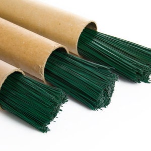 May include: Three rolls of green floral wire, each wrapped in brown paper, are shown against a white background.