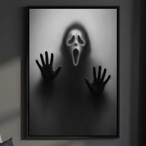 Può includere: Opera d'arte incorniciata in bianco e nero con la maschera di Scream e mani premute contro una superficie smerigliata. L'immagine crea un effetto spettrale e ombreggiato, ideale per l'arredamento di Halloween. L'opera d'arte è esposta in una stanza con una parete grigio scuro.