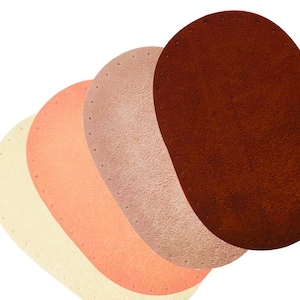 Może przedstawiać: Cztery owalne wkładki w różnych odcieniach beżu, brzoskwini i brązu. Każda wkładka ma teksturowaną powierzchnię i rząd małych otworów wzdłuż jednej krawędzi. Wkładki są ułożone warstwowo, z najciemniejszym brązem na wierzchu.