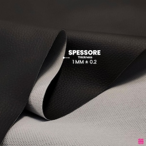 May include: Close-up of black leather fabric with a textured surface. The fabric is folded to reveal a light gray, perforated backing. Text indicates a thickness of 1 mm &plusmn; 0.2.