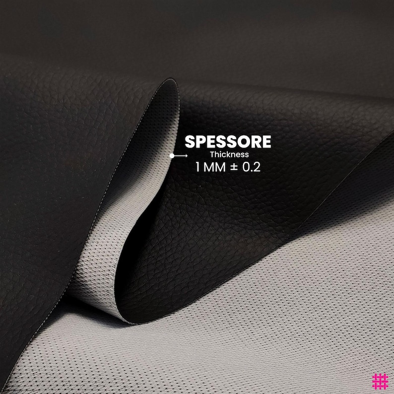 May include: Close-up of black leather fabric with a textured surface. The fabric is folded to reveal a light gray, perforated backing. Text indicates a thickness of 1 mm &plusmn; 0.2.