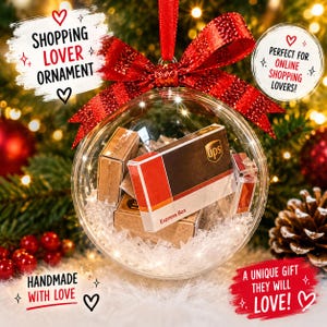 May include: A clear Christmas ornament filled with miniature UPS boxes, suspended by a red ribbon and bow. The ornament has the text "SHOPPING LOVER ORNAMENT" and "A UNIQUE GIFT THEY WILL LOVE!" on it. The ornament is handmade with love.