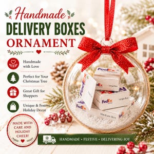 May include: A clear glass ornament with a red bow and ribbon, filled with miniature FedEx boxes and faux snow. The ornament has text that reads "Handmade Delivery Boxes Ornament".