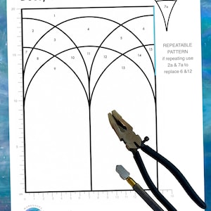 May include: A printed paper pattern for a Deco/Gothic Arch Window measuring 14.5cm by 20cm, featuring numbered sections, a ruler along the edges, and instructions for a repeatable pattern. A pair of black-handled pliers and a glass cutter are placed on top.