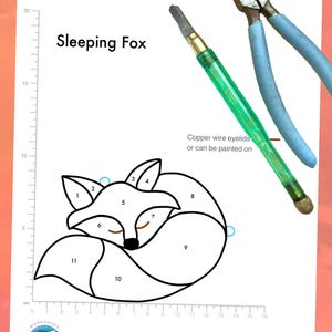 Pode incluir: Um desenho a preto e branco de uma raposa a dormir sobre um fundo branco. A raposa está dividida em 11 seções, numeradas de 1 a 11. O desenho tem 14 cm de largura e 10 cm de altura. O texto "Sleeping Fox" está escrito acima do desenho. O texto "Copper wire eyelids or can be painted on" está escrito abaixo do desenho.