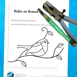 May include: A black and white line drawing of a robin on a branch. The drawing is numbered 1 through 11, indicating different pieces of glass to be used in a stained glass project. The design measurements are 10 cm wide by 6 cm high. The text "Robin on Branch" is at the top of the page.
