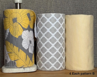 May include: Three decorative paper towel holders. One holder is on a stand and features a yellow floral pattern on a grey background. The other two holders have grey and white geometric patterns and a yellow striped pattern. The text "4 Each pattern B" is at the bottom.