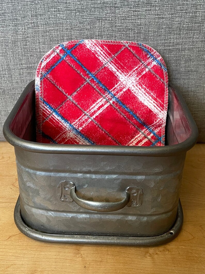 May include: A galvanized metal storage bin with a handle and a red and white plaid fabric liner.