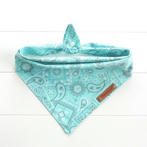 May include: A turquoise bandana with a paisley pattern and a brown leather tag that says "Chumleys".