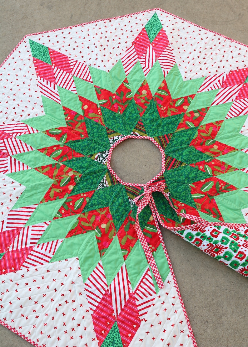 May include: A green, red, and white quilted Christmas tree skirt with a starburst design. The skirt has a red and white gingham trim and a tie closure.