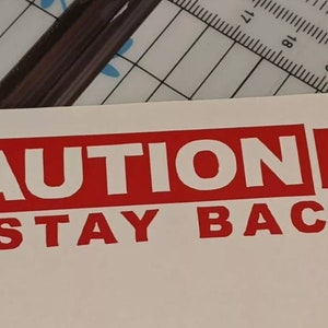 May include: Red and white vinyl sticker with the text "CAUTION K9 STAY BACK".