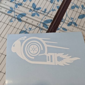 May include: White vinyl decal of a stylized snail with a turbocharger shell and a flame coming out of the back. The snail is on a light blue background.