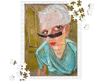 May include: A jigsaw puzzle featuring a portrait of a person with white hair, wearing sunglasses and a blue shirt. The person has red lipstick. Some puzzle pieces are detached from the main puzzle.