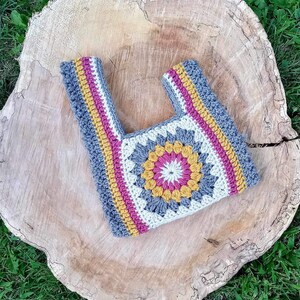 Crochet sunburst knot bag pattern. This beautiful motif crochet pattern is versatile and functional. This boho crochet bag pattern features a crochet flower sunburst design that makes this boho handbag really stand out.